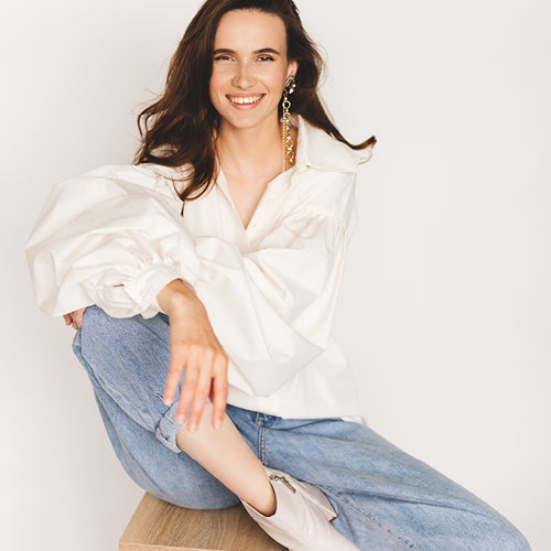 woman in cream shirt and jeans